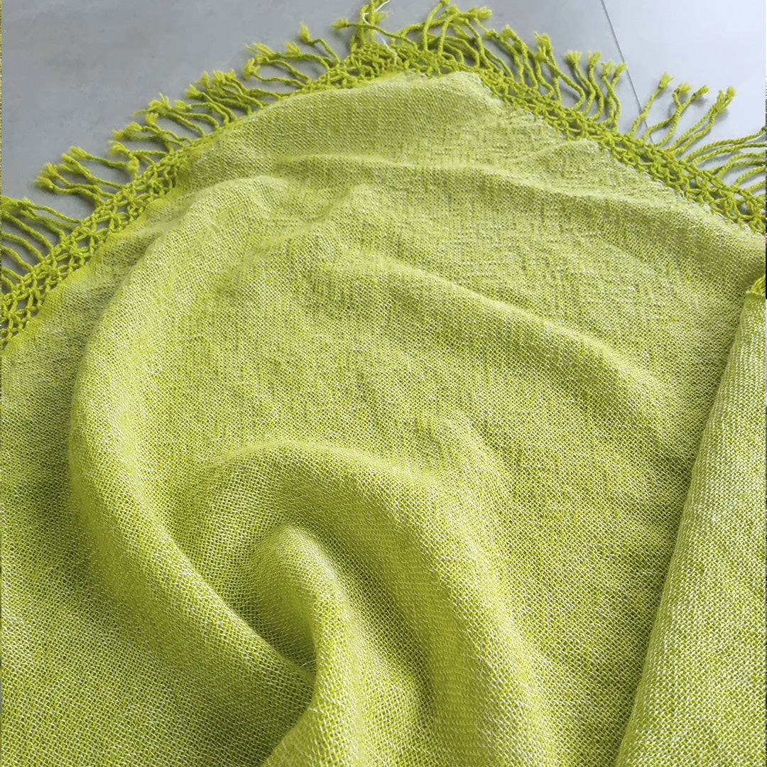 Bright green wool ruana wrap worn outdoors over the shoulders